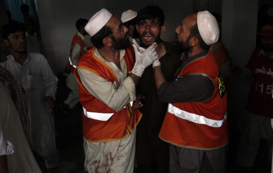 A man (C) cries over the death of his brother, who was killed in a bomb blast, at a hospital in Peshawar September 29, 2013. Twin blasts in the northwestern Pakistan city of Peshawar killed 33 people and wounded 70 on Sunday, a week after two bombings at a church in the frontier city killed scores, police and hospital authorities said. REUTERS/ Fayaz Aziz (PAKISTAN - Tags: POLITICS CIVIL UNREST CRIME LAW)