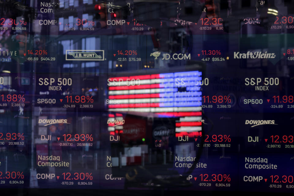 FILE - In this March 16, 2020 file photo, a United States flag is reflected in the window of the Nasdaq studio, which displays indices and stocks down, in Times Square, New York. Many U.S. companies have rushed to appoint Black members to their board of directors since racial justice protests swept the country last year. But in the two preceding years, progress on increasing racial diversity on boards stagnated, a new study revealed Tuesday, June 8, 2021. Nasdaq filed a proposal with the Security and Exchange Commission to adopt new listing rules requiring companies to publicly disclose their board diversity statistics. (AP Photo/Seth Wenig, File)