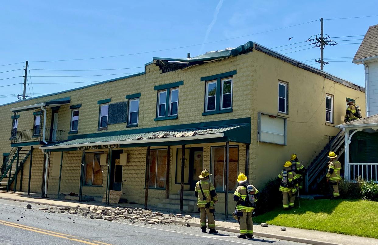 Hagerstown Fire Department firefighters check out the former Startzman's Hardware store on Sunday afternoon after what appears to be part of the facade collapsed onto South Potomac Street and the sidewalk.