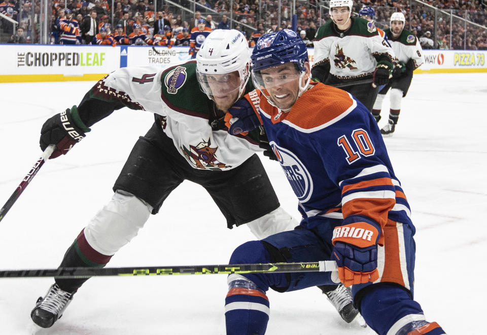 Arizona Coyotes' Juuso Valimaki (4) and Edmonton Oilers' Derek Ryan (10) battle for the puck during the second period of an NHL hockey game in Edmonton, Alberta, Wednesday, March 22, 2023. (Jason Franson/The Canadian Press via AP)