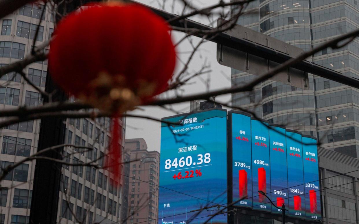 A large screen shows the latest stock exchange and economy data in Shanghai, China