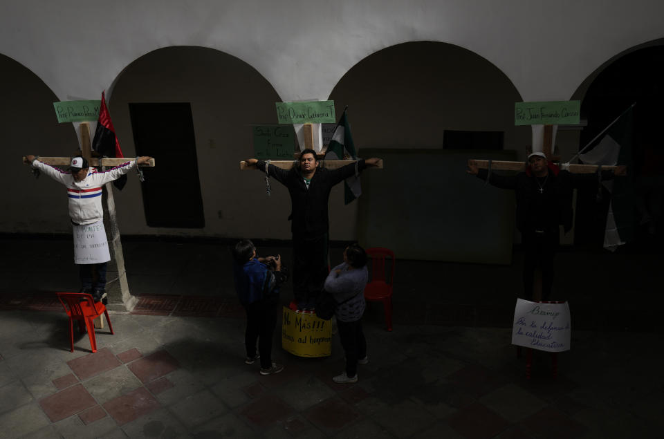 Educators symbolically crucify themselves on the sidelines of the May Day march in La Paz, Bolivia, Monday, May 1, 2023. Teachers are demanding higher pay and protesting the new state-imposed curriculum. (AP Photo/Juan Karita)