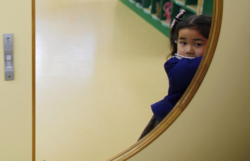 A girl opens the door of a teacher's staff room at the Emporium kindergarten in Koriyama, west of the tsunami-crippled Fukushima Daiichi nuclear power plant, Fukushima prefecture February 28, 2014. (REUTERS/Toru Hanai)