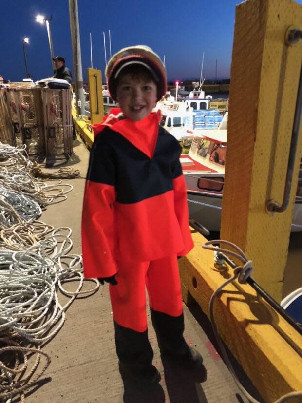 Trent Collins, dressed in the new 'oilers' fishing gear his grandfather gave him for his birthday, gets ready to head out on the boat on opening day.