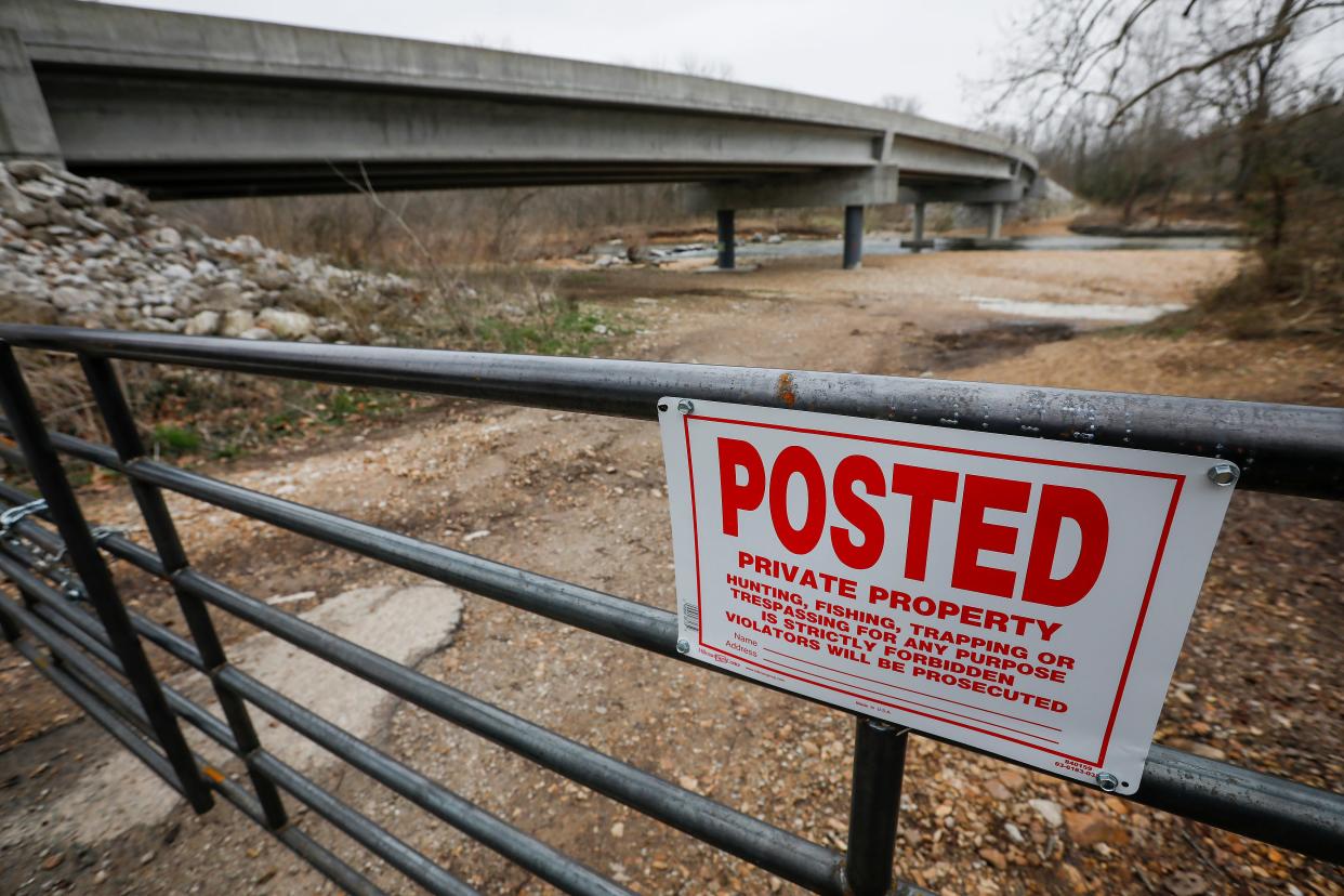 A metal gate and fence block access to the Finley River below Lindenlure Dam in Christian County.