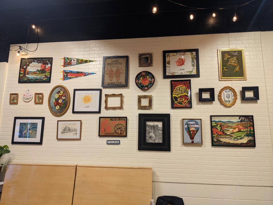 A wall with miscellaneous art scattered in different frames