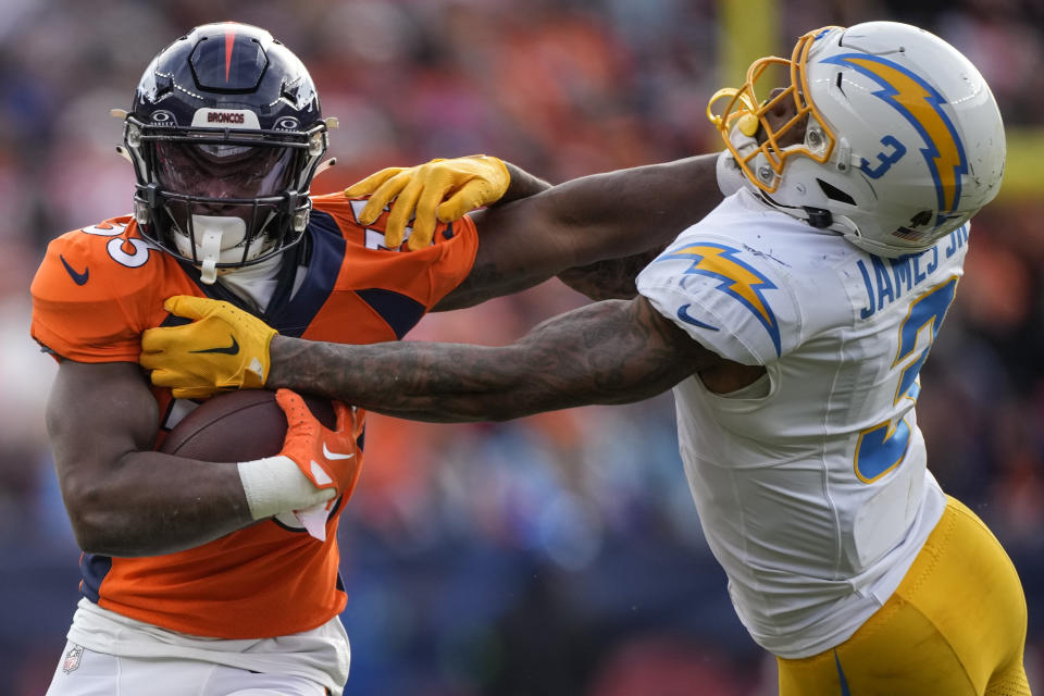 Denver Broncos running back Javonte Williams (33) hits Los Angeles Chargers safety Derwin James Jr. (3) during the first half of an NFL football game, Sunday, Dec. 31, 2023, in Denver. (AP Photo/David Zalubowski)