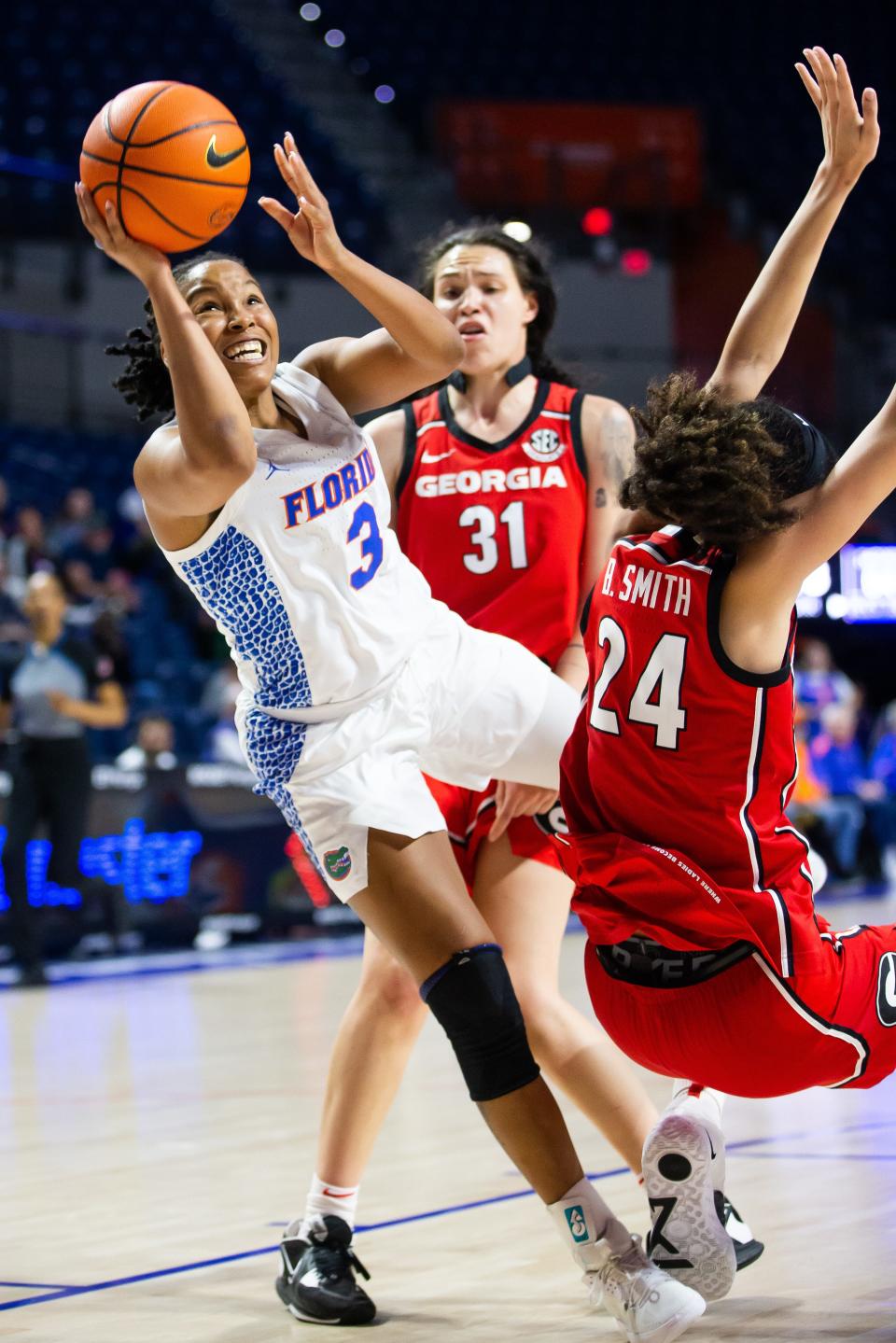 Florida Gators guard KK Deans (3) drives to the basket through Georgia Lady Bulldogs forward Brittney Smith (24)  the second half. The Florida women's basketball team hosted the Georgia Bulldogs at Exactech Arena at the Stephen C. O'Connell Center in Gainesville, FL on Sunday, January 8, 2023. The Bulldogs defeated the Gators 82-77. [Doug Engle/Ocala Star Banner]