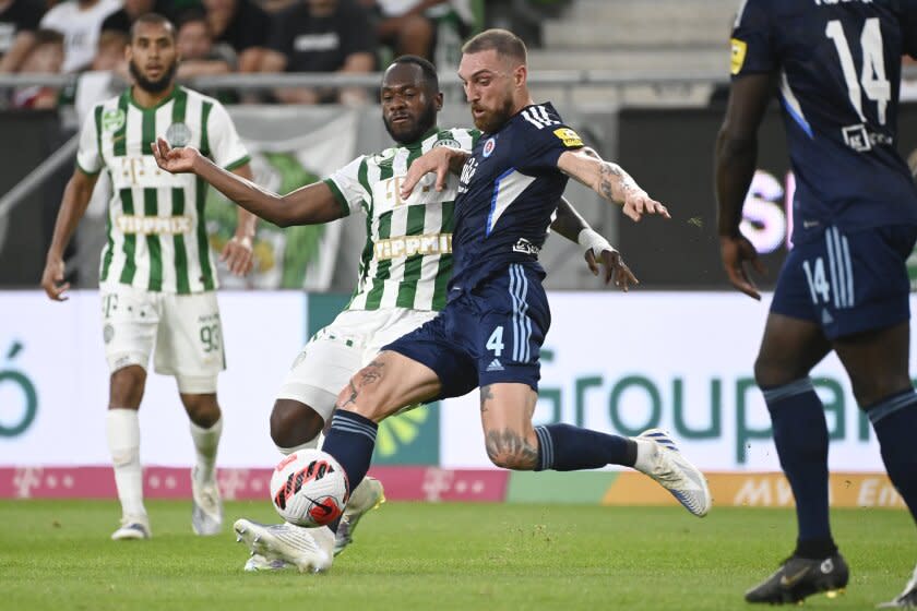 Guram Kashia (derecha) del Slovan Bratislava y Franck Boli de Ferencvaros disputan un balón en el partido de la fase previa de la Liga de Campeones, el 20 de julio de 2022, en Budapest. (Szilard Koszticsak/MTI vía AP)