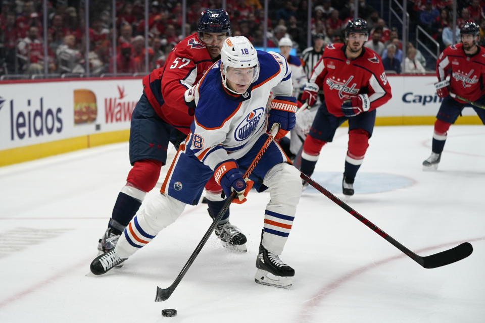 Edmonton Oilers left wing Zach Hyman (18) skates with the puck past Washington Capitals defenseman Trevor van Riemsdyk in the second period of an NHL hockey game, Monday, Nov. 7, 2022, in Washington. (AP Photo/Patrick Semansky)