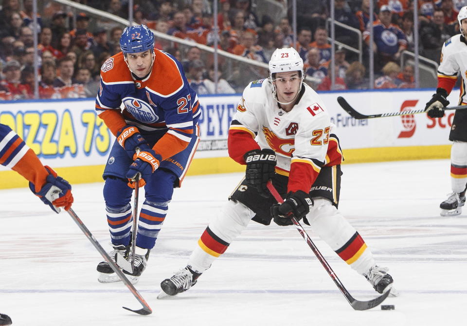 Calgary Flames' Sean Monahan (23) is chased by Edmonton Oilers' Milan Lucic (27) during first period NHL hockey action in Edmonton, Alberta on Sunday, Dec. 9, 2018. (Jason Franson/The Canadian Press via AP)