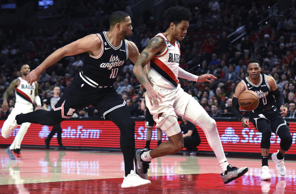 Los Angeles Clippers guard Eric Gordon, left, and Portland Trail Blazers guard Anfernee Simons go after a the ball during the second half of an NBA basketball game in Portland, Ore., Sunday, March 19, 2023. The Clippers won 117-102. (AP Photo/Steve Dykes)