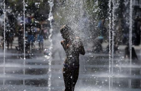 A girl cools off in water fountains on a summer's day in Nice, France, July 12, 2017. REUTERS/Eric Gaillard/Files