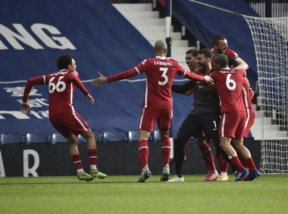 Liverpool's goalkeeper Alisson celebrates with teammates after scoring his side's second goal during the English Premier League soccer match between West Bromwich Albion and Liverpool at the Hawthorns stadium in West Bromwich, England, Sunday, May 16, 2021. (AP Photo/Rui Vieira, Pool)