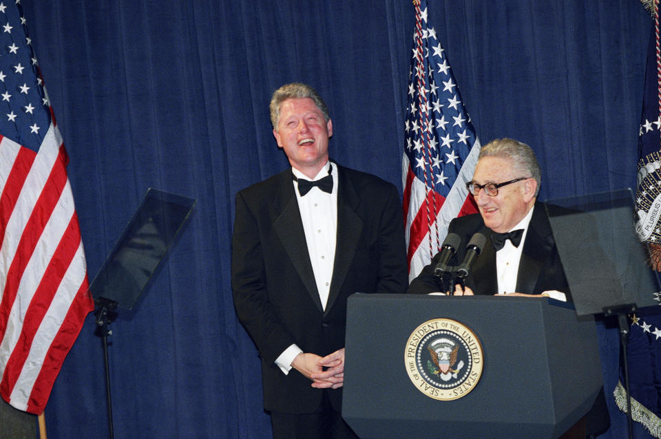 FILE - President Bill Clinton, left, and former Secretary of State Henry Kissinger laugh together after Clinton gave the closing remarks at a national policy conference, March 1, 1995, in Washington. Kissinger, the diplomat with the thick glasses and gravelly voice who dominated foreign policy as the United States extricated itself from Vietnam and broke down barriers with China, died Wednesday, Nov. 29, 2023. He was 100. (AP Photo/J. Scott Applewhite, File)