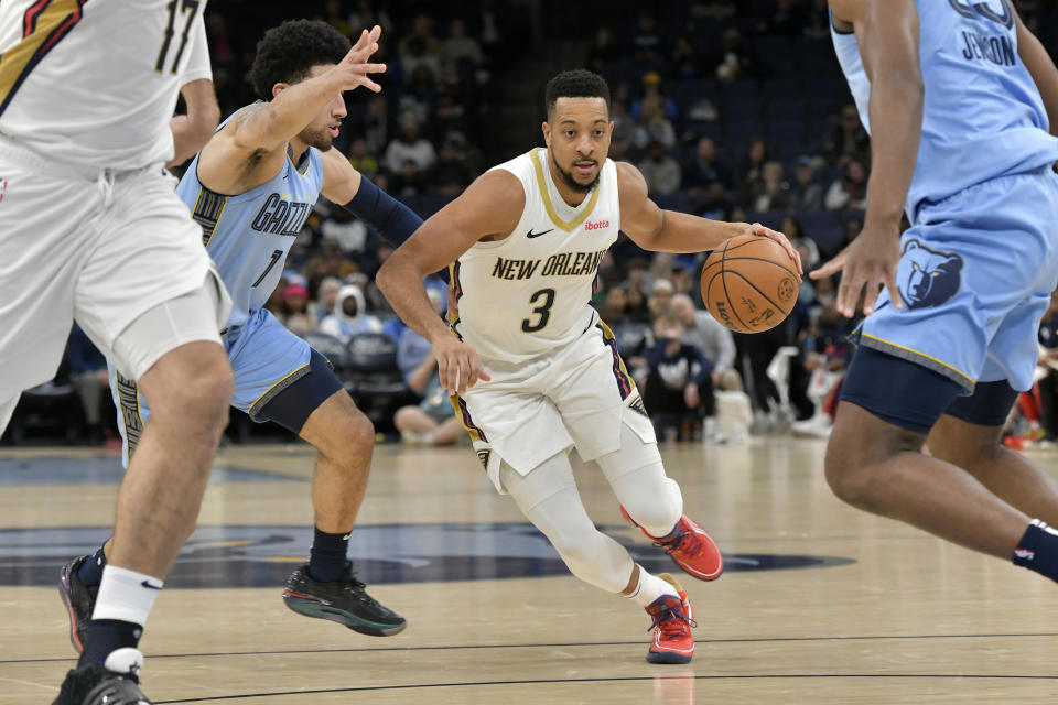 New Orleans Pelicans guard CJ McCollum (3) handles the ball against Memphis Grizzlies guard Scotty Pippen Jr. (1) in the first half of an NBA basketball game Monday, Feb. 12, 2024, in Memphis, Tenn. (AP Photo/Brandon Dill)