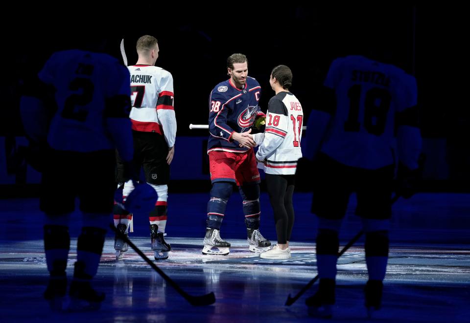 Blue Jackets center Boone Jenner shakes the hand of Ohio State defenseman Sophie Jaques after she dropped the ceremonial puck before a game against the Senators.