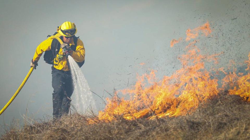 A firefighter attacks the edge of the Lizzie Fire in the hills above San Luis High School on Oct. 30, 2023.