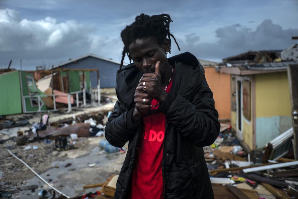 Vladimir Safford, an immigrant from Haiti, lights a cigarette next to the rubble if his home, in the aftermath of Hurricane Dorian, in Abaco, Bahamas, Monday, Sept. 16, 2019. Dorian hit the northern Bahamas on Sept. 1, with sustained winds of 185 mph (295 kph), unleashing flooding that reached up to 25 feet (8 meters) in some areas. (AP Photo/Ramon Espinosa)