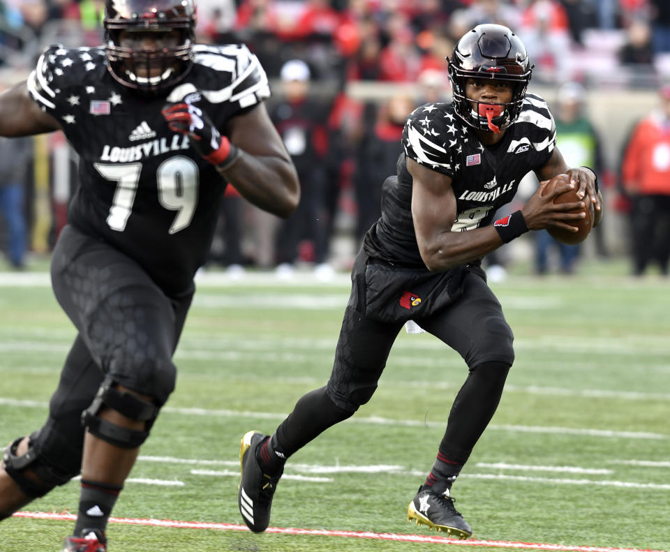 Louisville quarterback Lamar Jackson (8) runs the ball behind the blocking of Louisville offensive lineman Kenny Thomas (79) during the first half of an NCAA college football game, Saturday, Nov. 11, 2017, in Louisville, Ky. (AP Photo/Timothy D. Easley)