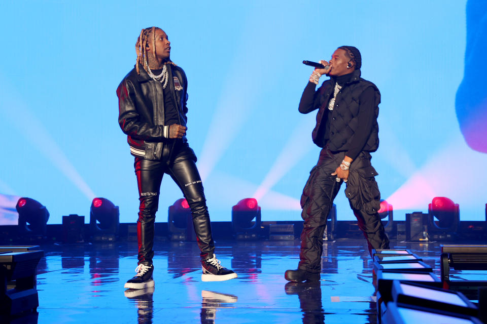 American rappers Lil Durk and Lil Baby wearing black performing on stage.