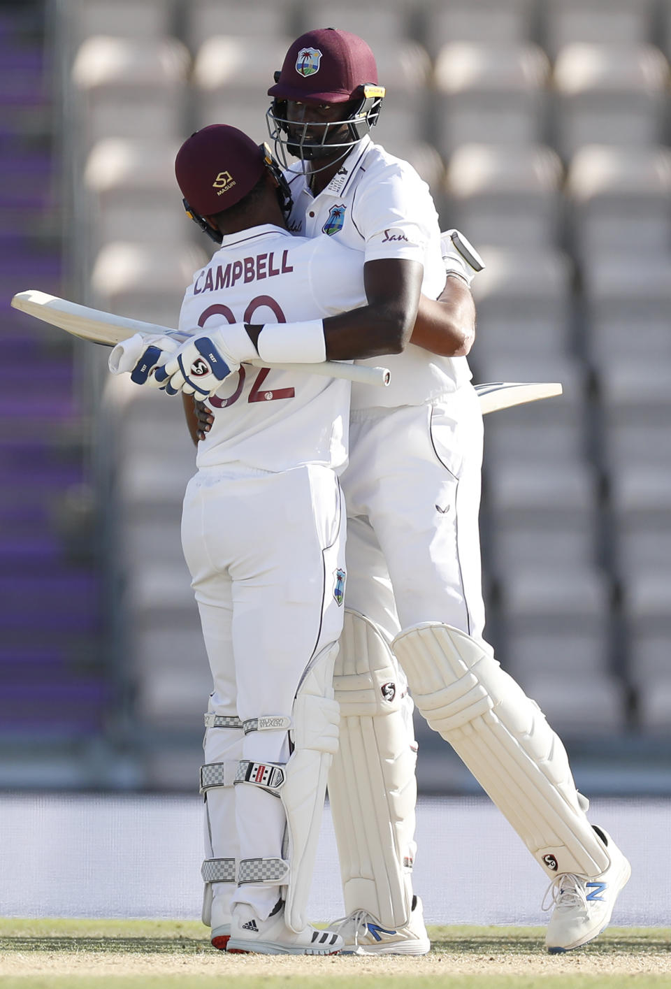 West Indies captain Jason Holder, right, hugs teammate John Campbell after their win on the fifth day of the first cricket Test match between England and West Indies, at the Ageas Bowl in Southampton, England, Sunday, July 12, 2020. (Adrian Dennis/Pool via AP)