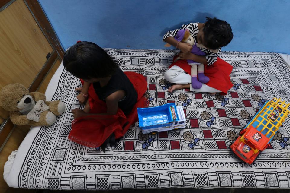 In this picture taken on May 11, 2021, twin sisters Tripti and Pari, who lost both their parents due to the Covid-19 coronavirus, play with their toys at a relative's home in Bhopal. - Thousands of children have lost at least one parent in the new pandemic wave ravaging India, where there were already millions of orphans. - TO GO WITH AFP STORY children-health-India-coronavirus by Aishwarya KUMAR (Photo by Gagan NAYAR / AFP) / TO GO WITH AFP STORY children-health-India-coronavirus by Aishwarya KUMAR (Photo by GAGAN NAYAR/AFP via Getty Images)