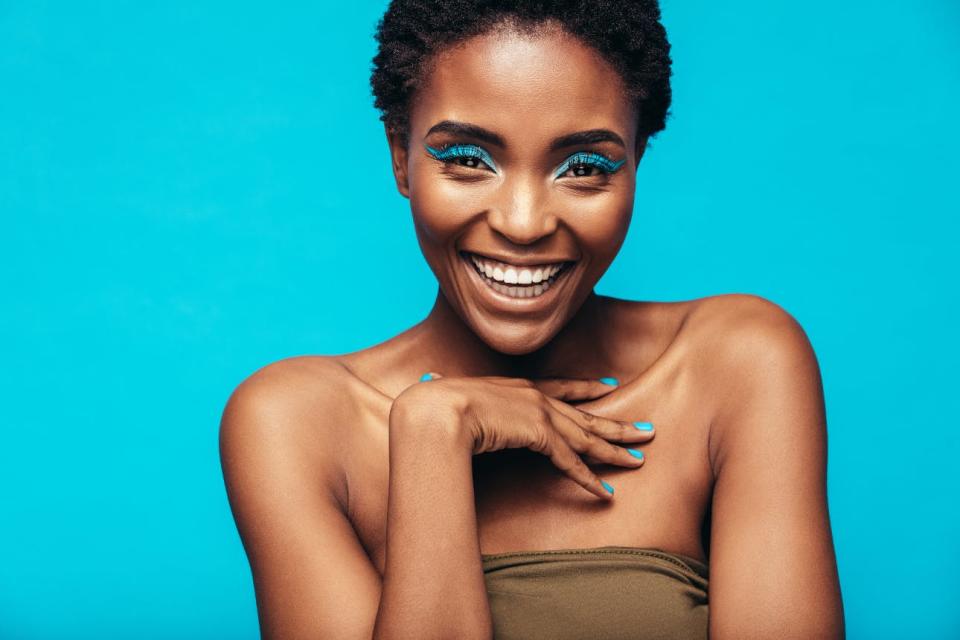 A woman shows off bright blue makeup