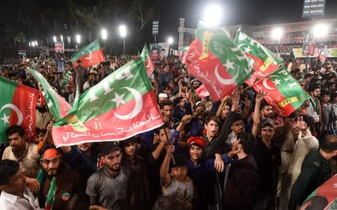 Supporters of Pakistani cricket star-turned-politician and head of the Pakistan Tehreek-e-Insaf (PTI) Imran Khan (unseen) gather at his political campaign rally - Credit: AFP