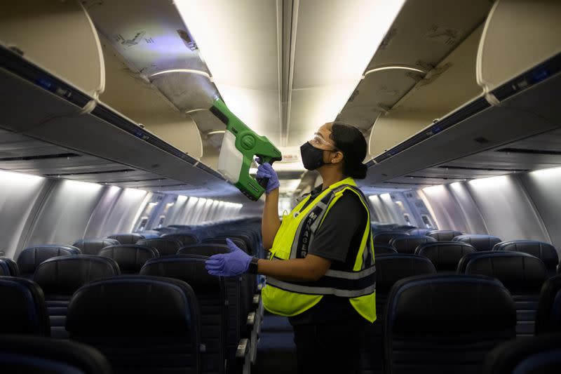 FILE PHOTO: Worker demonstrates use of an electrostatic disinfectant sprayer on United Airlines plane at IAH George Bush Intercontinental Airport in Houston