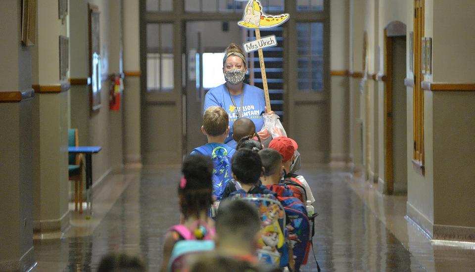 Edison Elementary School kindergarten teacher Sara Ulrich leads students inside to begin the first day of school on Aug. 30. Masks are not required in Erie school district buildings now that Erie County's COVID-19 Community Level was lowered to medium.