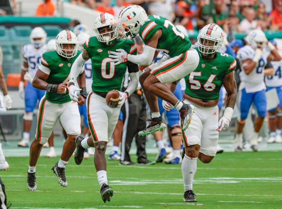 Miami Hurricanes safety Kamren Kinchens (24) celebrates with safety James Williams (0) after Williams intercepts the ball in the first quarter at Hard Rock Stadium in Miami Gardens on Saturday, October 22, 2022.