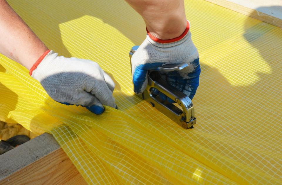 Contractor installs yellow vapor barrier to prevent excessive humidity levels in the home. 