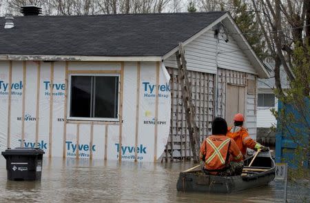 Hydro-Quebec workers check on evacuated homes in a flooded residential neighbourhood in Rigaud, Quebec, Canada May 7, 2017. REUTERS/Christinne Muschi