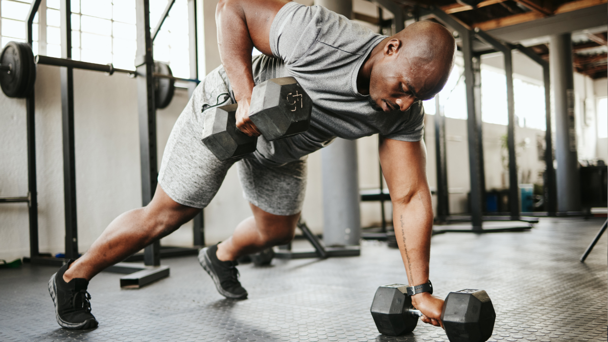  Man doing dumbbell renegade row. 