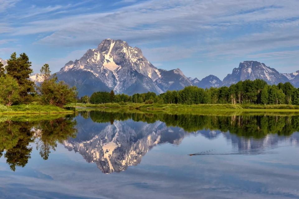 The Teton Range reflects in the water of Oxbow Bend