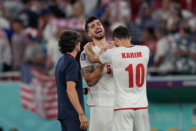 Saeid Ezatolahi is consoled after the loss to the United States at the World Cup.