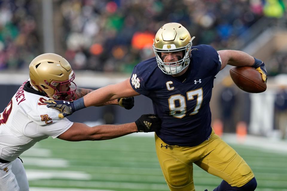 Notre Dame's Michael Mayer (87) runs past Boston College defensive back Jaiden Woodbey during the first half of an NCAA college football game, Saturday, Nov. 19, 2022, in South Bend, Ind. (AP Photo/Darron Cummings)