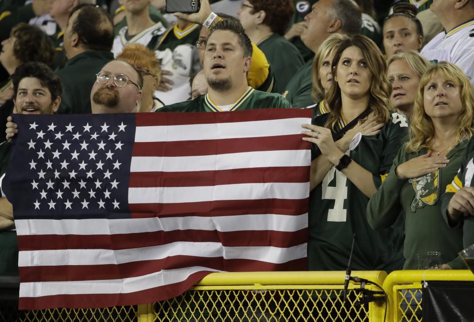 Fans in Green Bay stand to attention during the playing of the national anthem on Thursday. (AP) 