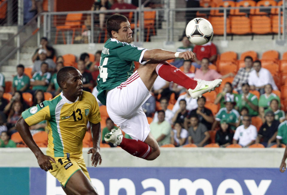 Javier Hernandez of Mexico takes a shot at the goal past Charles Pollard of Guyana during their 2014 World Cup qualifying soccer match.