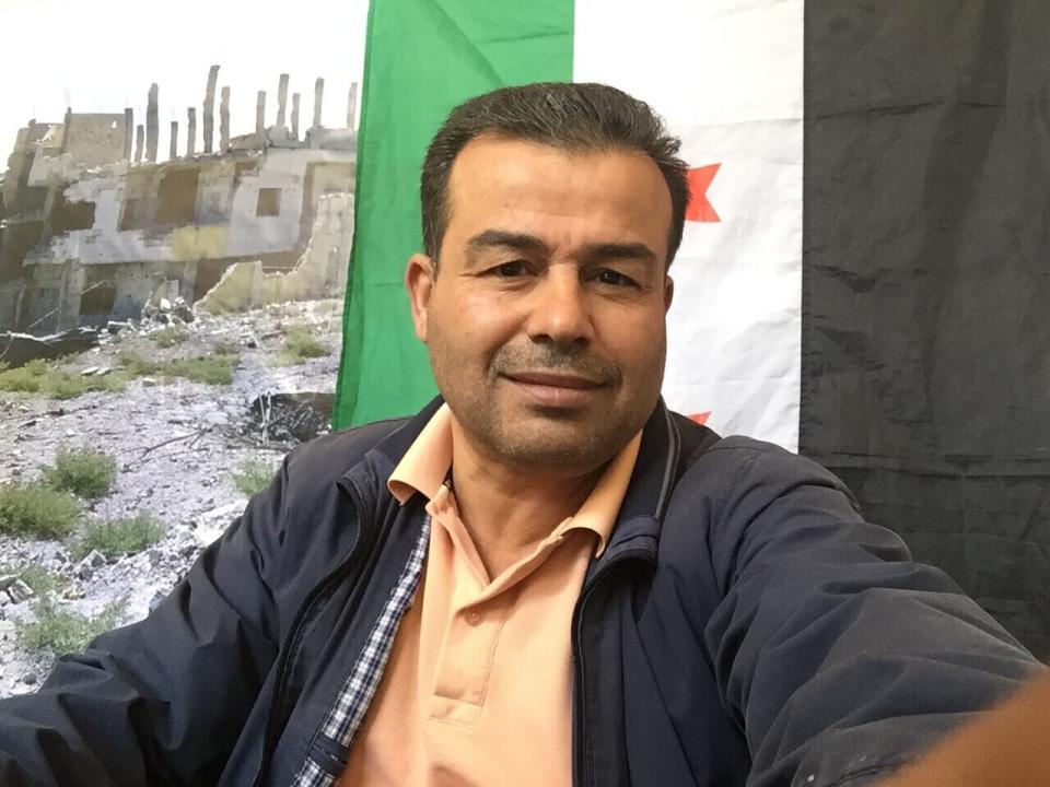 This August 2018 photo provided by Syrian opposition activist Ahmed al-Masalmeh, shows a selfie of him taken in front of the Syrian revolutionary flag, in Daraa, Syria. Al-Masalmeh helped organize anti-government protests in the southern city of Daraa in March 2011. He was among the first to join the protests against the Assad family rule amid Arab Spring uprisings in 2011. (Ahmed al-Masalmeh via AP)