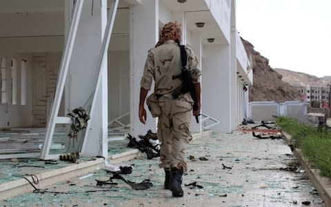 A fighter from the separatist Southern Transitional Council gather on February 25, 2018, at the site of two suicide car bombings - Credit: AFP