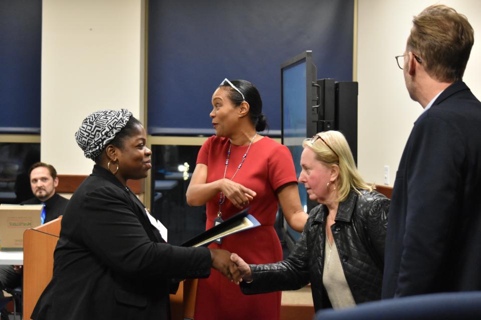 South Bend School Corp. employee and aspiring teacher Ramie George, left, shakes hands with National Education Association-South Bend President Linda Lucy as George receives her scholarship to earn a bachelor's degree in education.