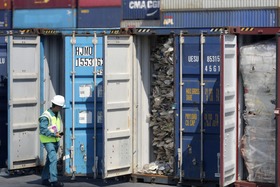 A Malaysian official inspects a container filled with plastic waste shipment prior to sending it to the Westport in Port Klang, Malaysia, Tuesday, May 28, 2019. Malaysia says it will send back some 3,000 metric tonnes (330 tons) of non-recyclable plastic waste to countries including the U.S., U.K., Canada and Australia in a move to avoid becoming a dumping ground for rich nations. (AP Photo / Vincent Thian)