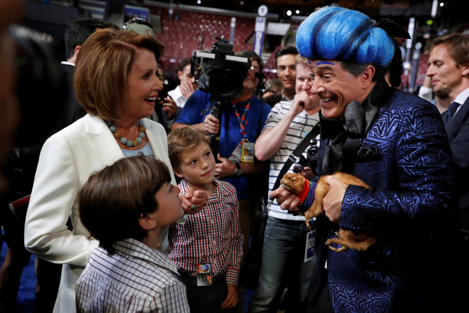 U.S. House Minority Leader Nancy Pelosi (D-CA) and two of her grandsons greet comedian Stephen Colbert (R) on the floor.