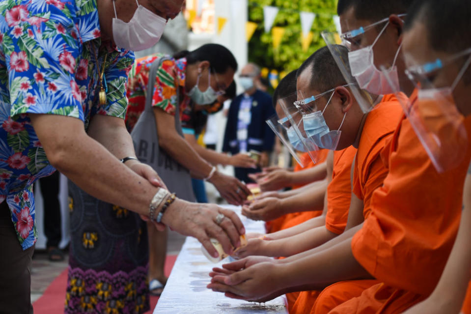 People queue to pour water on a Buddhist statue as they celebrate Songkran, also known as the Thai New Year, at Wat Pho temple in Bangkok, Thailand on 13 April 2021.<span class="copyright">Anusak Laowilas—NurPhoto/Getty Images</span>