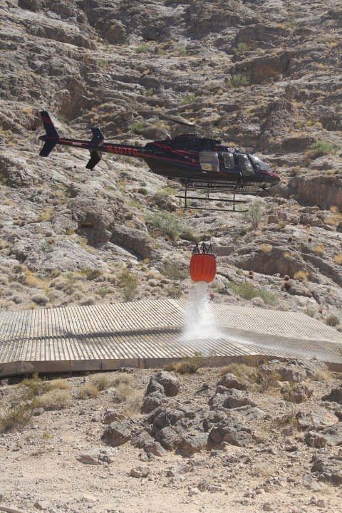 A helicopter drops water into a guzzler collection apron in the Muddy Mountains south of Valley of Fire State Park on Aug. 10, 2020. (Doug Nielsen/Nevada Department of Wildlife)
