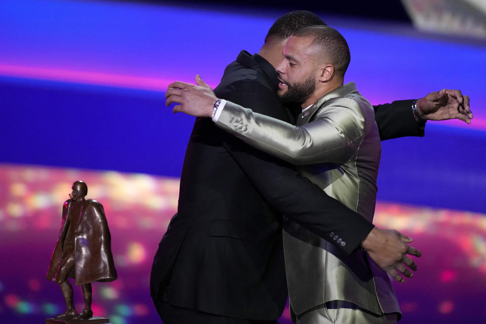 Walter Payton Player of the Year Award winner, Dallas Cowboys' Dak Prescott, right, hugs last year's recipient, Calais Campbell, during the NFL Honors award show ahead of the Super Bowl 57 football game, Thursday, Feb. 9, 2023, in Phoenix. (AP Photo/David J. Phillip)