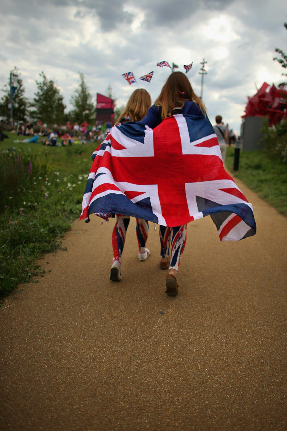 LONDON, ENGLAND - JULY 28: Members of the public wearing Union Jack clothing arrive on day one of the London 2012 Olympic Games at the Olympic Park on July 28, 2012 in London, England. (Photo by Jeff J Mitchell/Getty Images)