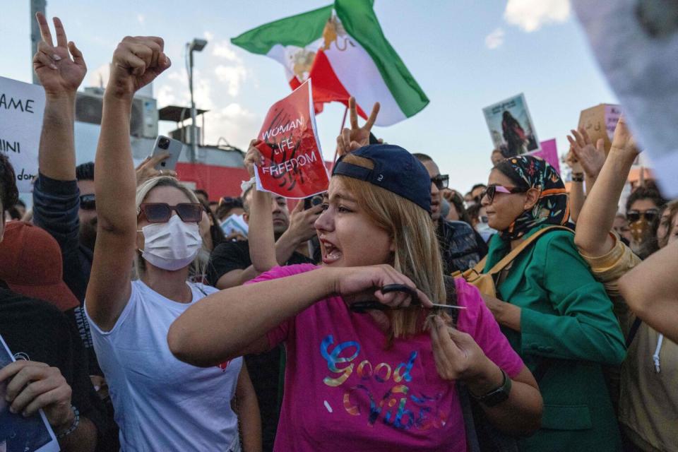 Protester cutting her hair during a demonstration